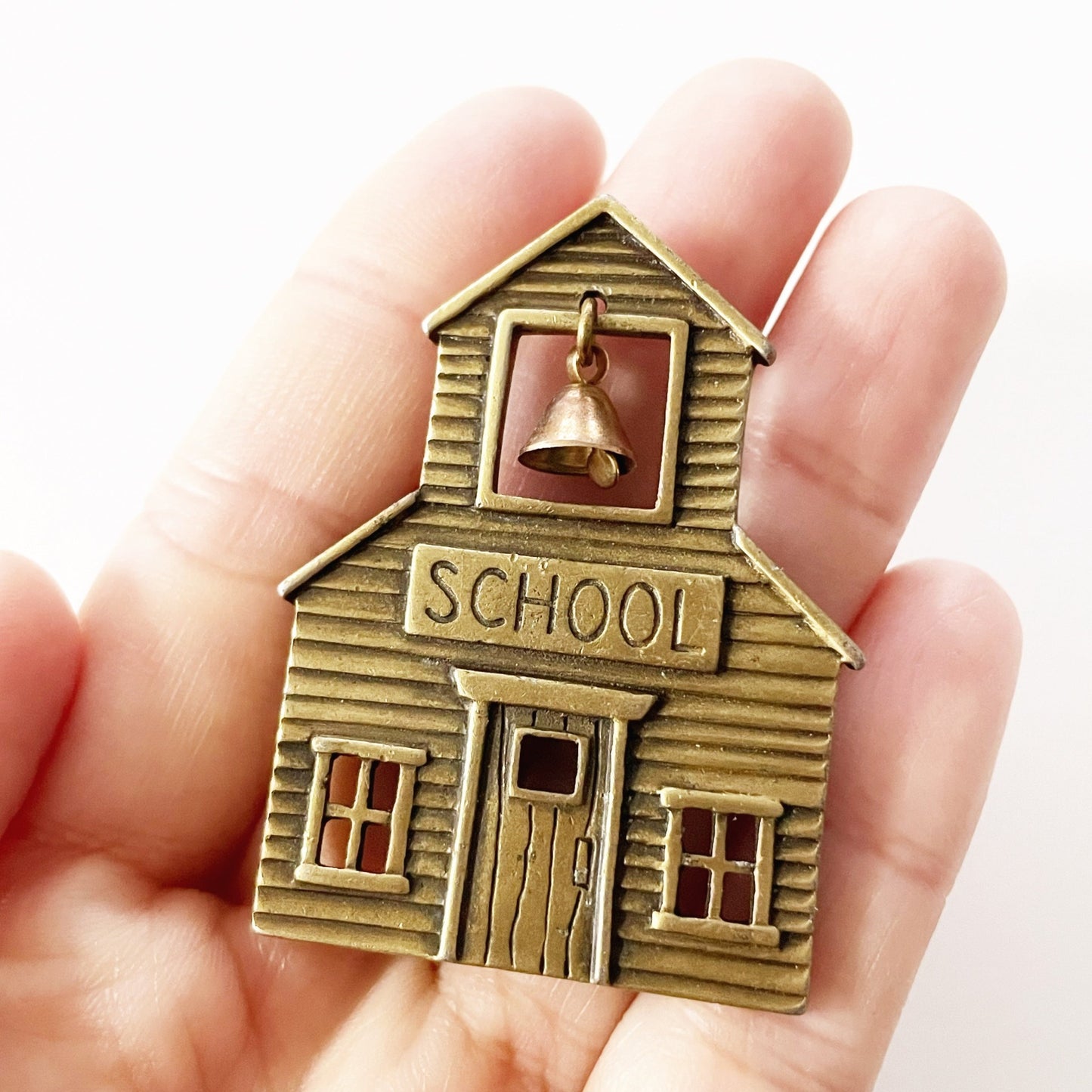 Vintage JJ signed brass tone school brooch with a dangling bell
