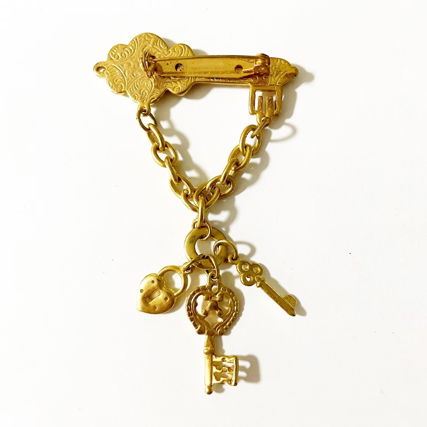 Vintage 1928 jewelry gold tone key-themed dangle brooch