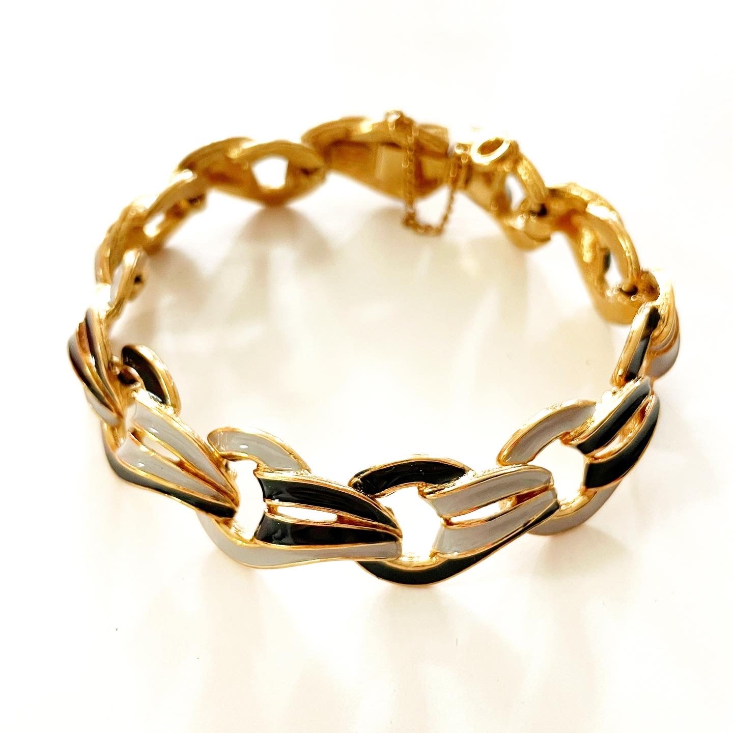Vintage 80s D’ORLAN signed 22-karat gold plated black and grey enamel link bracelet with a safety chain closure.