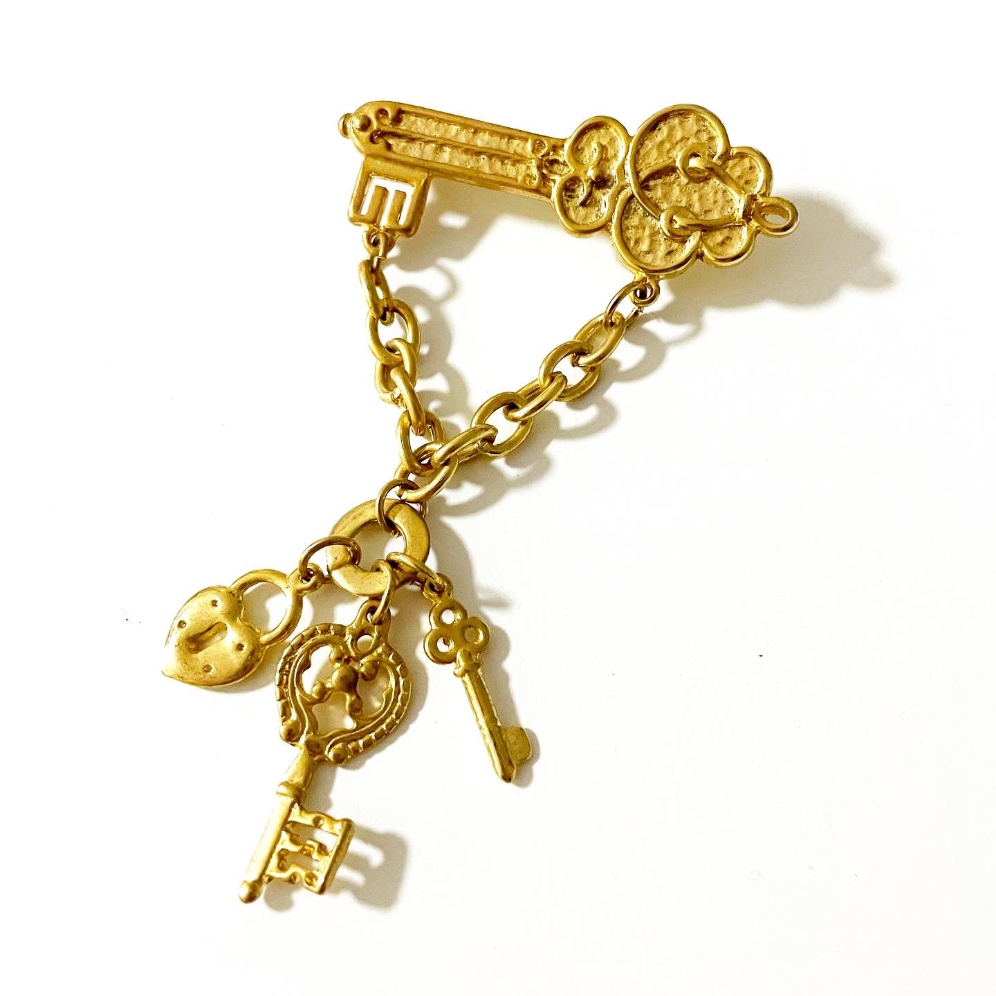Vintage 1928 jewelry gold tone key-themed dangle brooch
