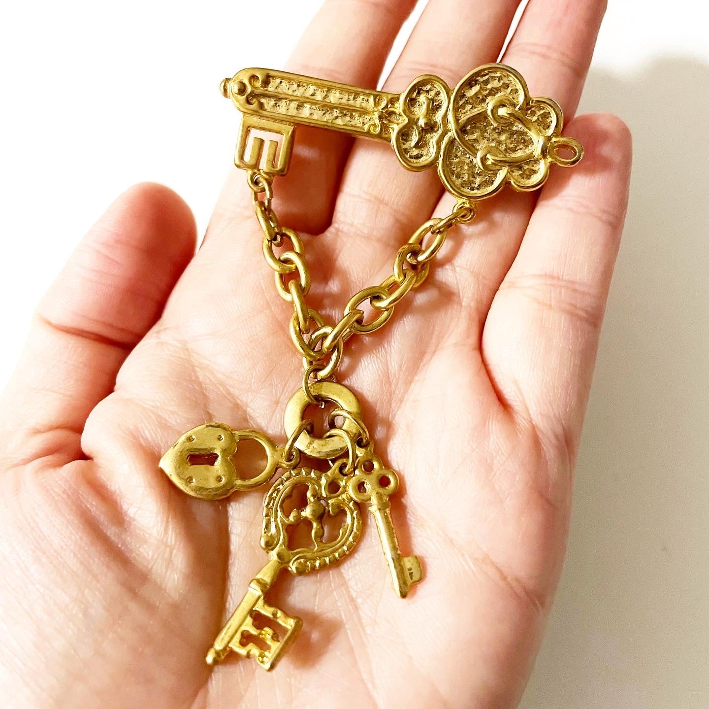 Vintage 1928 jewelry gold tone key-themed dangle brooch