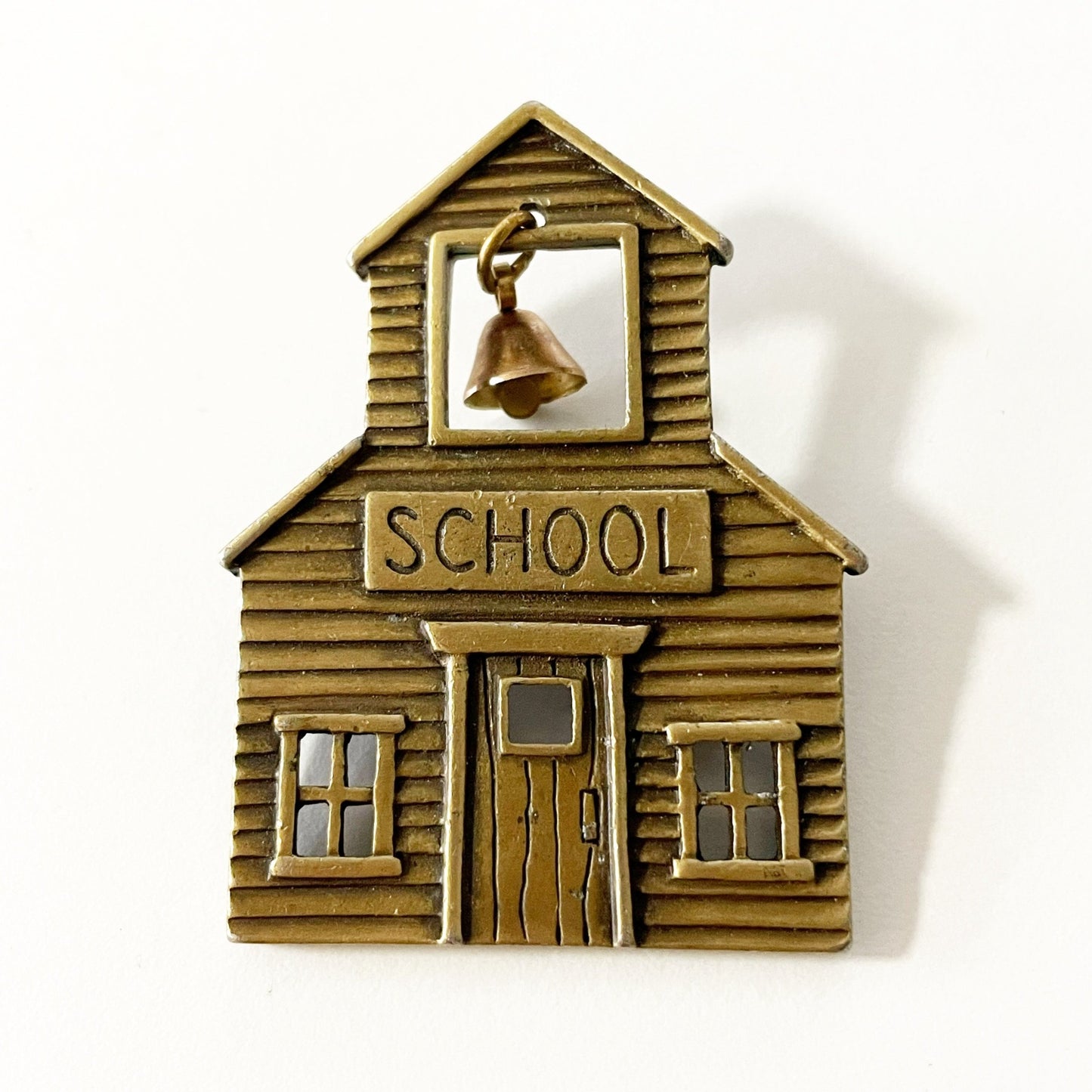 Vintage JJ signed brass tone school brooch with a dangling bell